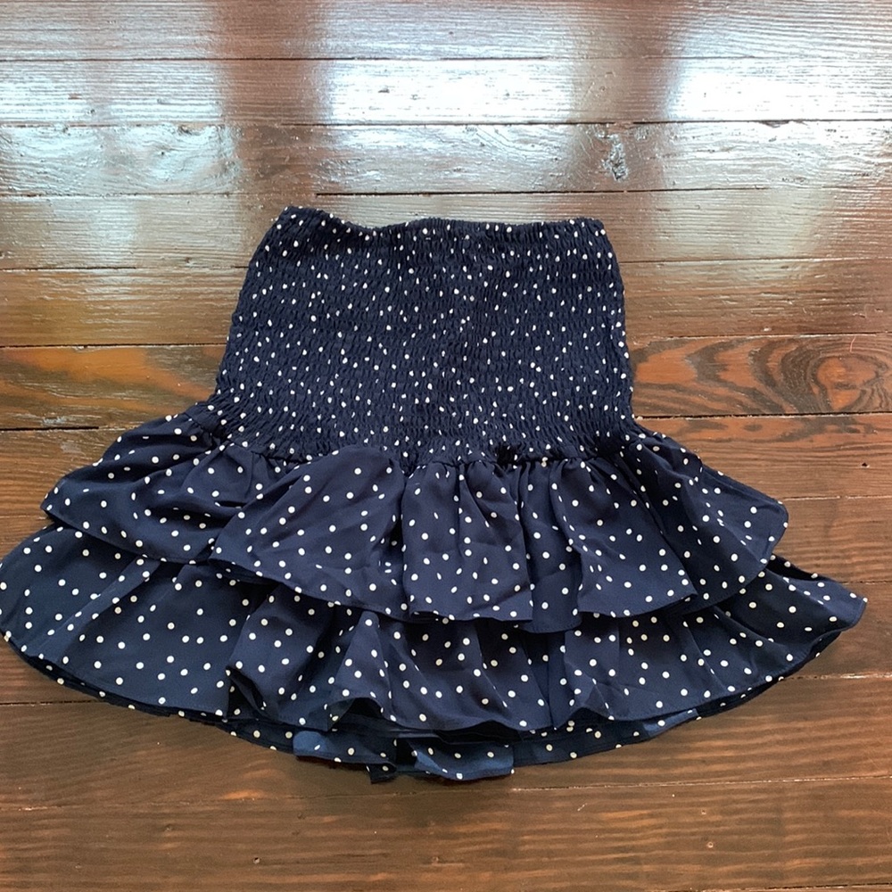 Navy mini skirt with white polka dots. Size XS but can fit larger. Lightly worn.